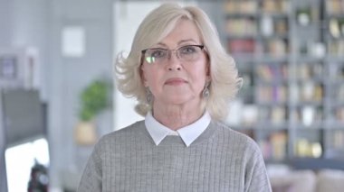 Kameraya gülümseyen neşeli yaşlı kadın portresi
