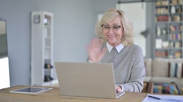 Mulher velha fazendo Video Chat no Laptop no escritório moderno — Vídeo de Stock