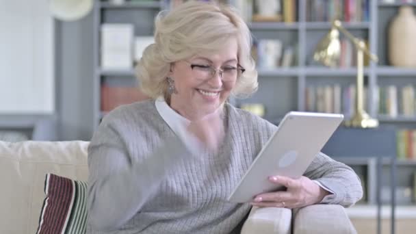 Alegre anciana celebrando el éxito en la tableta — Vídeo de stock