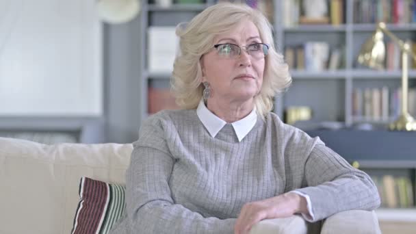 Gorgeous Old Woman Sitting on Sofa and Looking Around — Stock Video