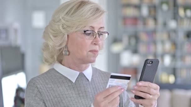 Porträt einer alten Frau, die online mit dem Smartphone bezahlt — Stockvideo
