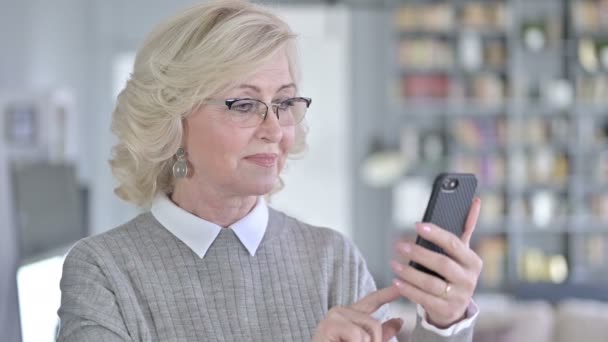 Porträt einer fokussierten alten Frau mit Smartphone — Stockvideo