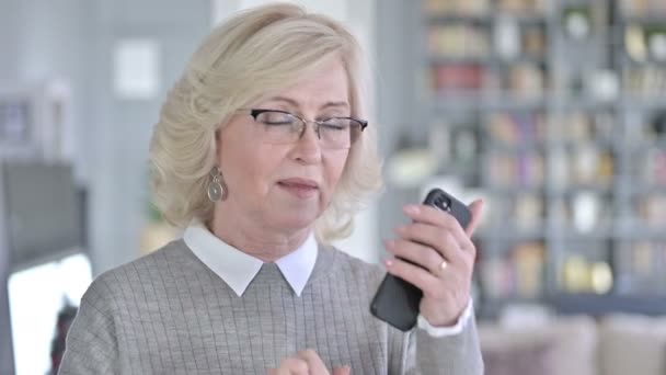Портрет веселой старухи, разговаривающей по смартфону — стоковое видео