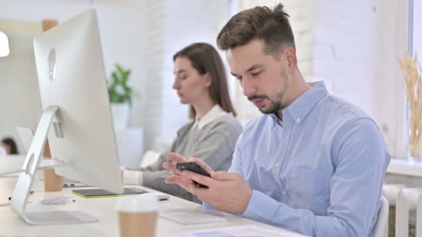 Professionnel créatif sérieux utilisant le smartphone dans le bureau — Video