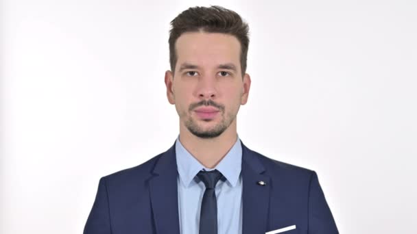 Porträt eines jungen Geschäftsmannes, der in die Kamera blickt, weißer Hintergrund — Stockvideo