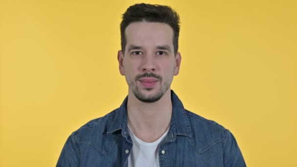 Porträt eines erfolgreichen Jungunternehmers mit Siegeszeichen, gelber Hintergrund — Stockvideo