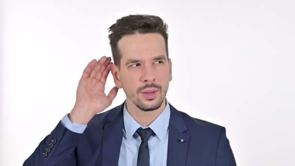 Porträt eines neugierigen jungen Geschäftsmannes, der heimlich zuhört, weißer Hintergrund — Stockvideo