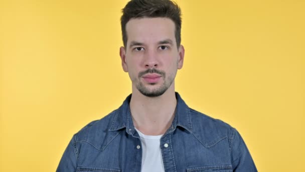 Retrato de un joven grosero mostrando el dedo medio, fondo amarillo — Vídeos de Stock