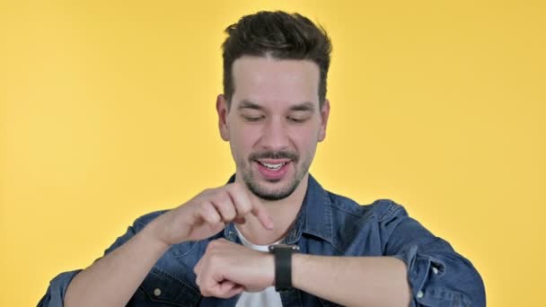 Porträt eines professionellen jungen Mannes mit Smartwatch, gelber Hintergrund — Stockvideo