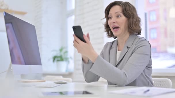 Mulher velha criativa comemorando o sucesso no Smartphone — Vídeo de Stock