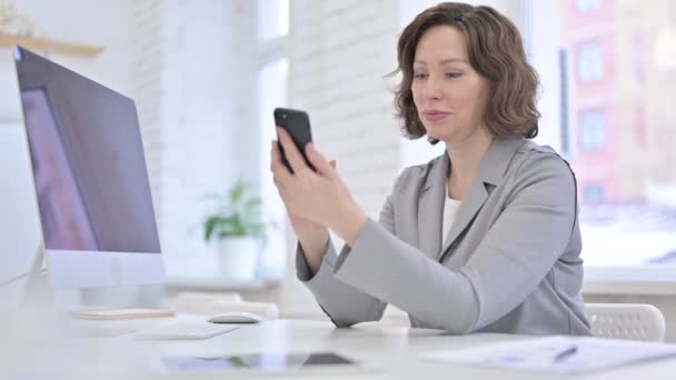 Creative Old Woman using Smartphone on Office Desk — 图库视频影像