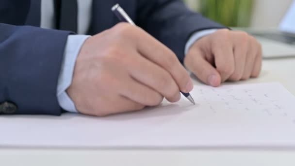 Primer plano de la escritura de hombre de negocios en papel — Vídeo de stock