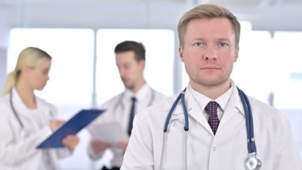 Portrait d'un médecin masculin sérieux regardant la caméra — Video