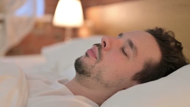 Portré fiatal férfi próbál aludni az ágyban — Stock videók