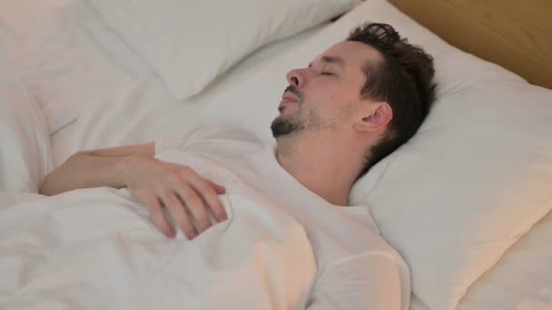 Sjuk ung man som har hosta i sängen — Stockvideo