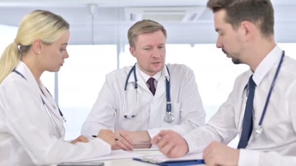Professionelle männliche Ärzteteam auf Papier im Büro — Stockvideo