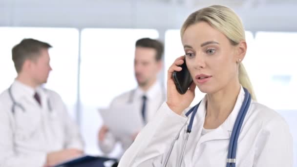 Porträtt av professionell kvinnlig doktor talar på smartphone — Stockvideo