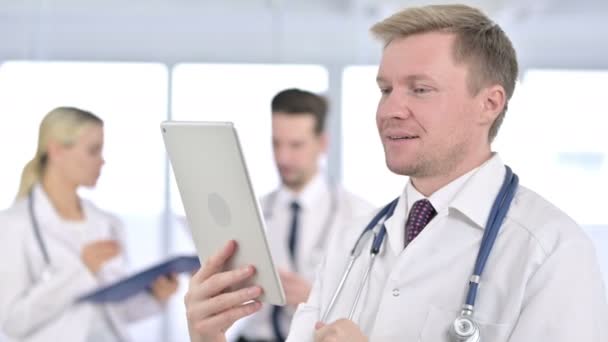 Портрет профессионального врача-мужчины, ведущего видео-чат на планшете — стоковое видео