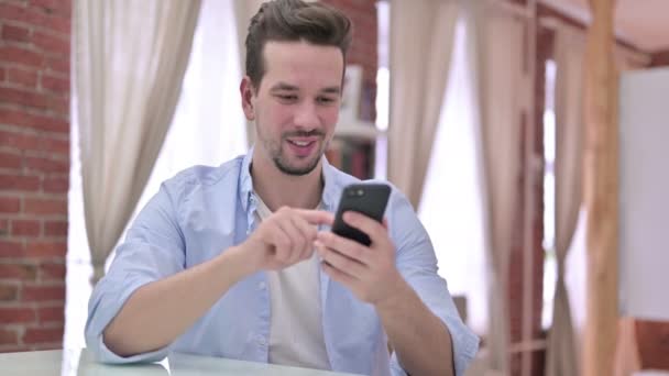 Ehrgeiziger junger Mann nutzt Smartphone — Stockvideo