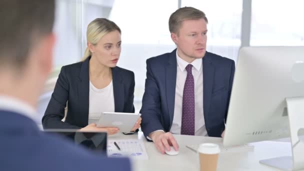 Equipe de negócios focada trabalhando juntos em desktop e tablet — Vídeo de Stock