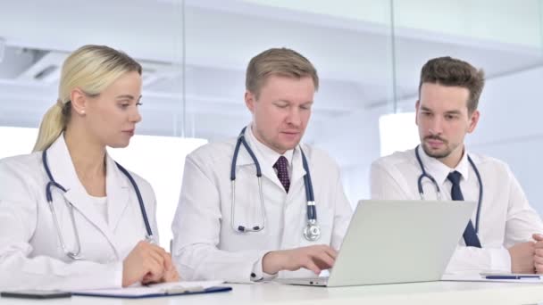 Equipe séria de médicos trabalhando no laptop juntos — Vídeo de Stock