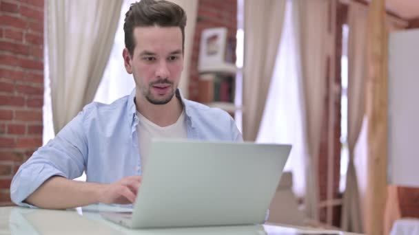 Mladý muž slaví úspěch na notebooku — Stock video
