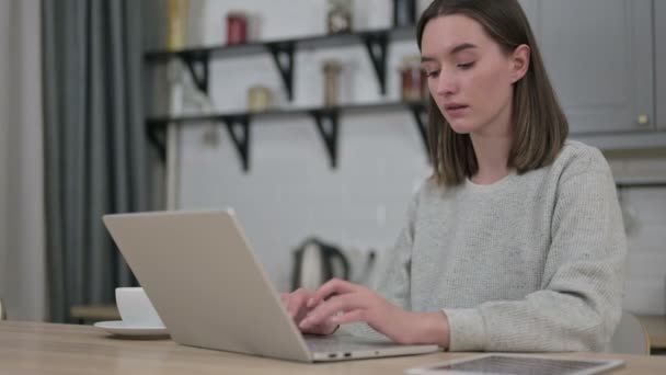 Mujer joven enfocada trabajando en el ordenador portátil en la sala de estar — Vídeos de Stock