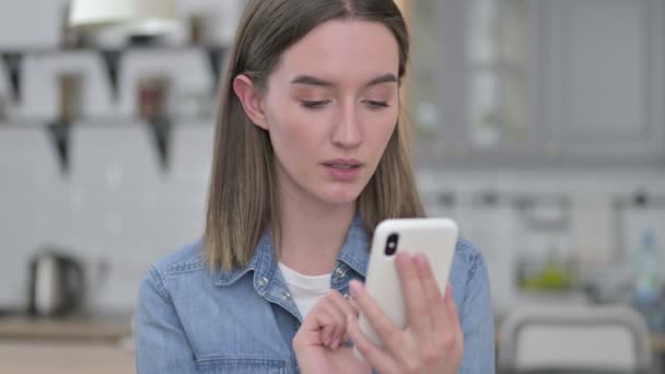 Портрет молодої жінки, що реагує на втрати на смартфон — стокове відео