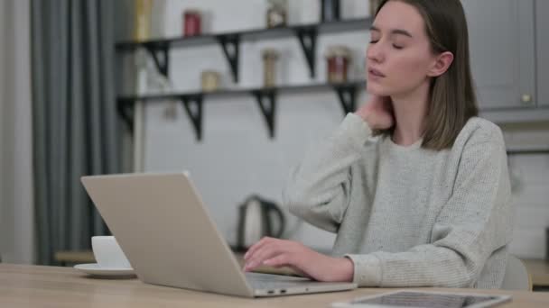 Schöne junge Frau, die am Laptop arbeitet und Nackenschmerzen hat — Stockvideo