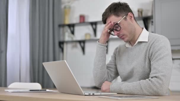Müder Mann hat Kopfschmerzen bei der Arbeit am Laptop — Stockvideo