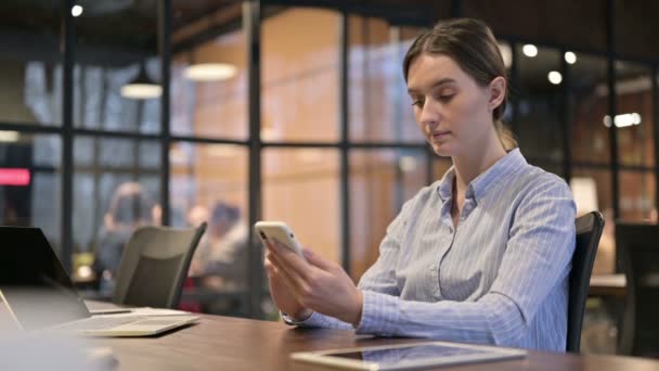 Mujer joven usando Smartphone en el trabajo — Vídeos de Stock