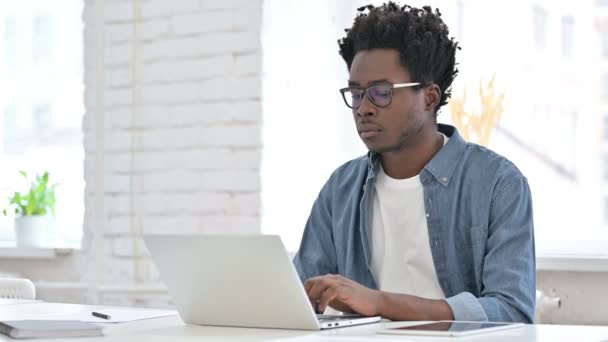 Hombre joven africano trabajando en el ordenador portátil — Vídeos de Stock