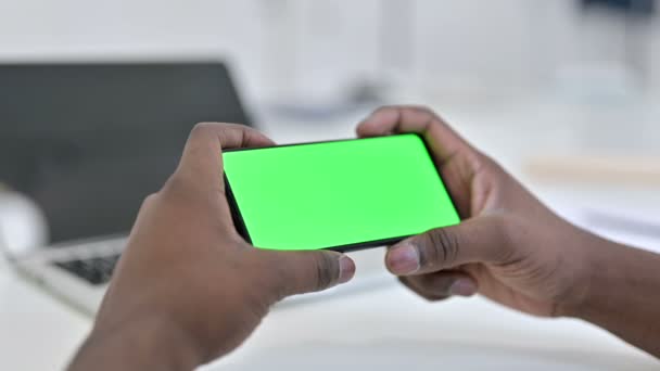 L'homme africain regarde la vidéo sur l'écran vert de smartphone, clé de Chroma — Video