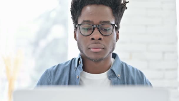 Retrato de un joven africano celebrando en un ordenador portátil — Vídeo de stock