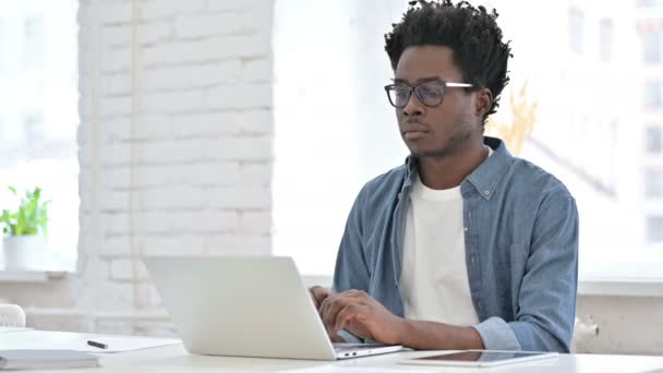 Jonge Afrikaanse man werkt op laptop — Stockvideo