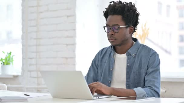 Молодой африканский человек празднует успех на ноутбуке — стоковое видео