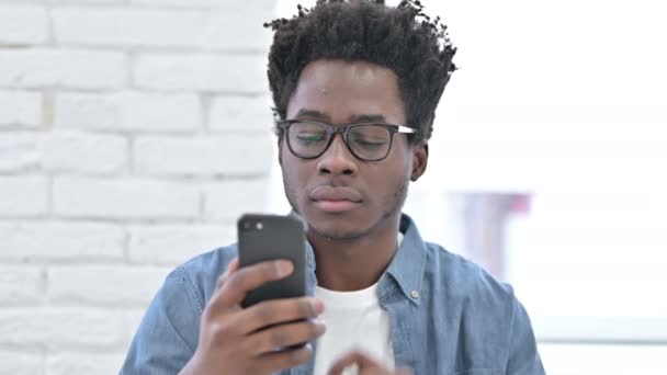 Joven africano hombre obtener sorprendido en el teléfono inteligente — Vídeo de stock