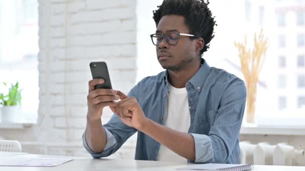 Ung afrikansk man rulla på Smartphone — Stockvideo