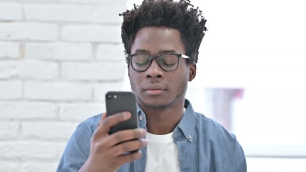 Jonge Afrikaanse man viert succes op Smartphone — Stockvideo