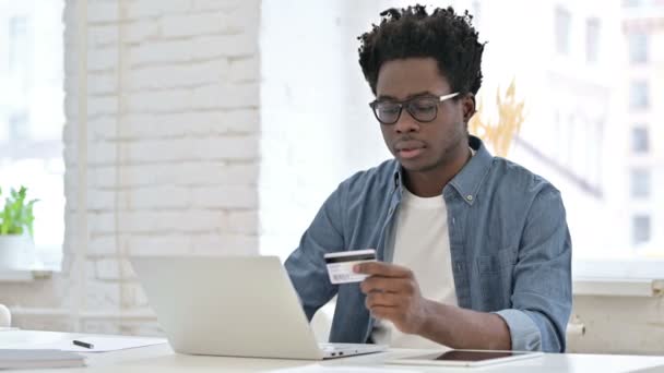 Успешные онлайн-покупки от молодого африканца на ноутбуке — стоковое видео