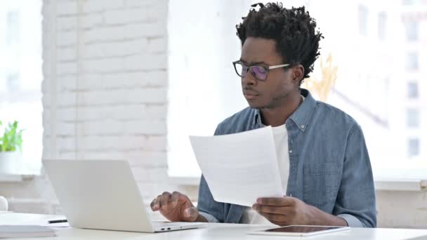 Jonge Afrikaanse man werkt aan document — Stockvideo