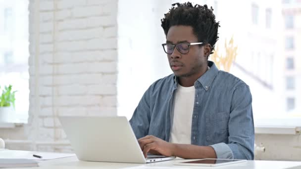 Joven africano con dolor de cabeza en el ordenador portátil — Vídeo de stock