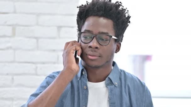 Enojado joven africano hombre enojado en el teléfono inteligente — Vídeos de Stock