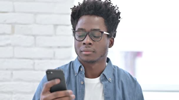 Молодой африканский человек разговаривает по смартфону — стоковое видео