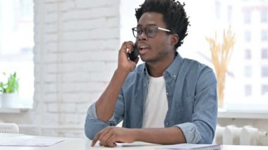Akıllı telefondan konuşan hırslı bir Afrikalı. 