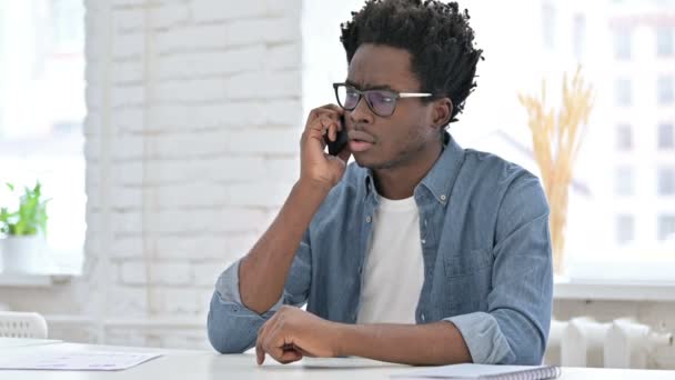 Boos jonge Afrikaanse man schreeuwen op telefoon — Stockvideo