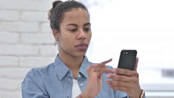 Молода африканка використовує смартфон, повідомлення — стокове відео