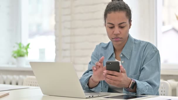 Mulher Africana jovem usando Smartphone e Laptop — Vídeo de Stock