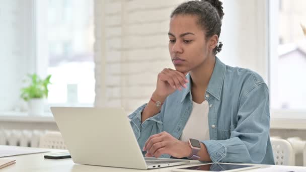 Mujer africana joven pensativa que trabaja en el ordenador portátil — Vídeo de stock