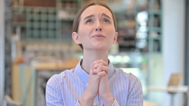 Портрет надеющейся молодой предпринимательницы, молящейся — стоковое видео